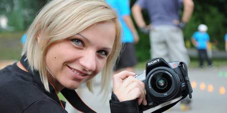 Attraktive blonde Frau mit Sony DSLR Kamera
